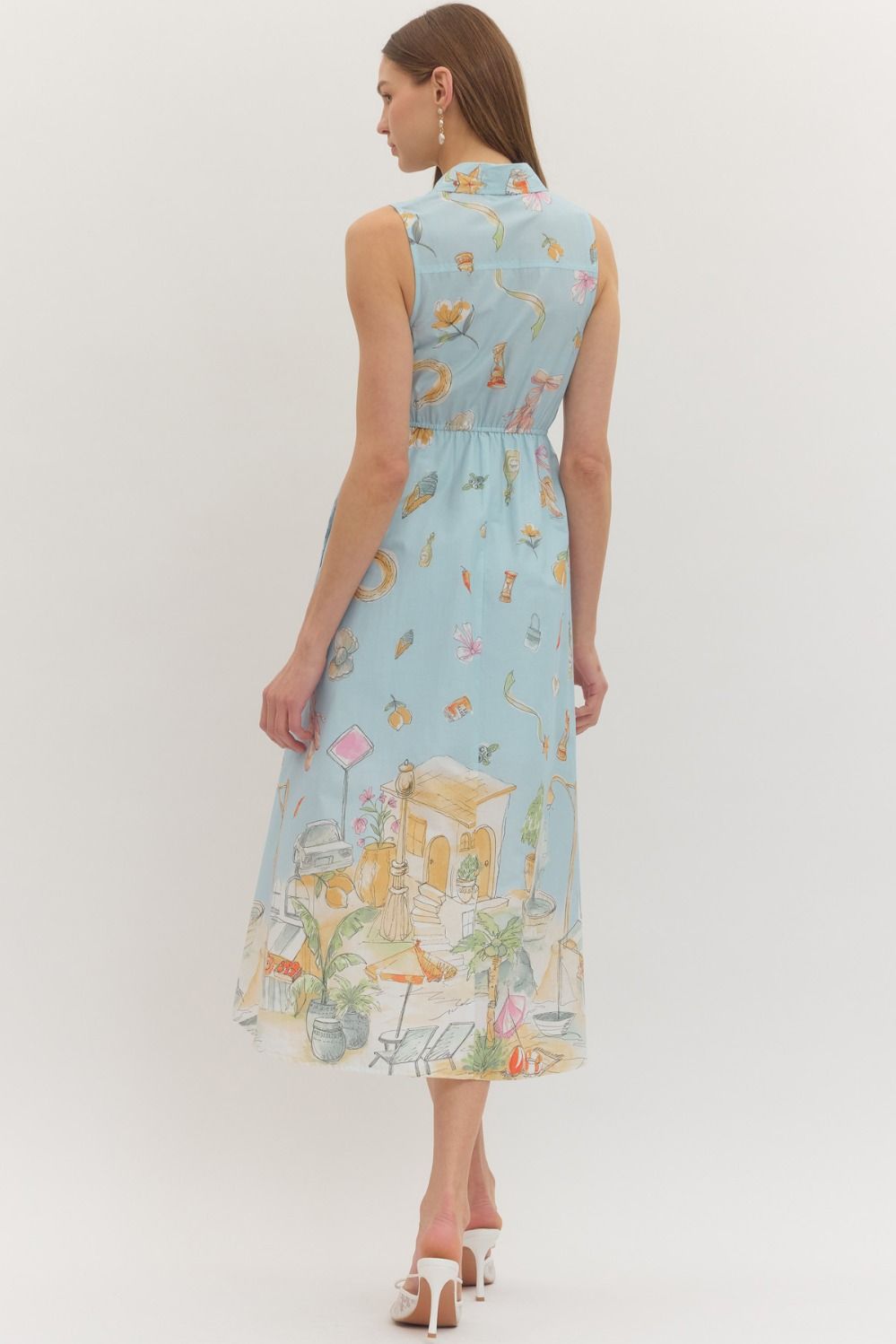 Woman wearing a light blue dress with colorful floral and nature print on a white background