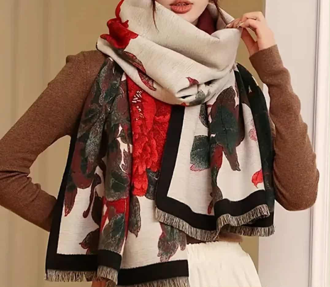  “Woman styling floral jacquard wrap scarf with brown sweater and white skirt”