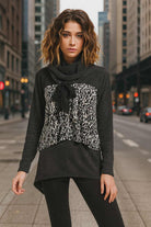 Model wearing charcoal & white print sweater with cowl neck and bow detail