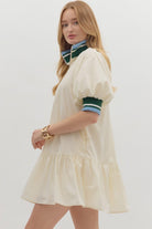 Sporty chic cream half-zip dress with puff sleeves and contrast striped collar side view