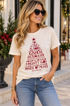 Women's cream Isaiah 9:6 Christmas graphic tee featuring distressed red Bible verse typography arranged in a Christmas tree design with star and Prince of Peace message.