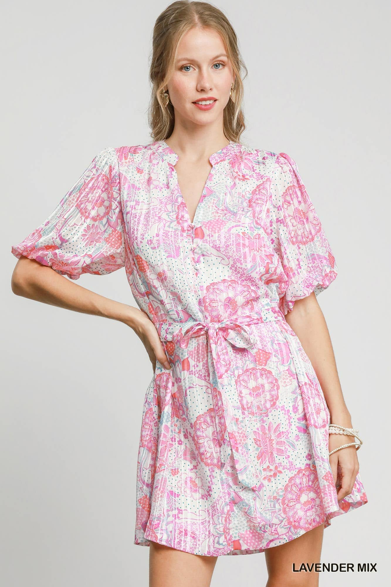 Model wearing a lavender mix floral mini dress with puff sleeves and tie waist