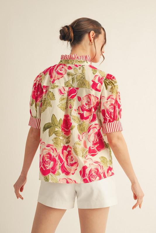 Woman wearing a floral blouse with pink roses on a beige background, back view