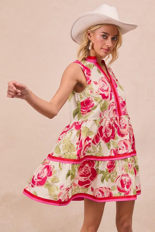 Woman wearing a floral dress with pink roses and a white cowboy hat on a beige background
