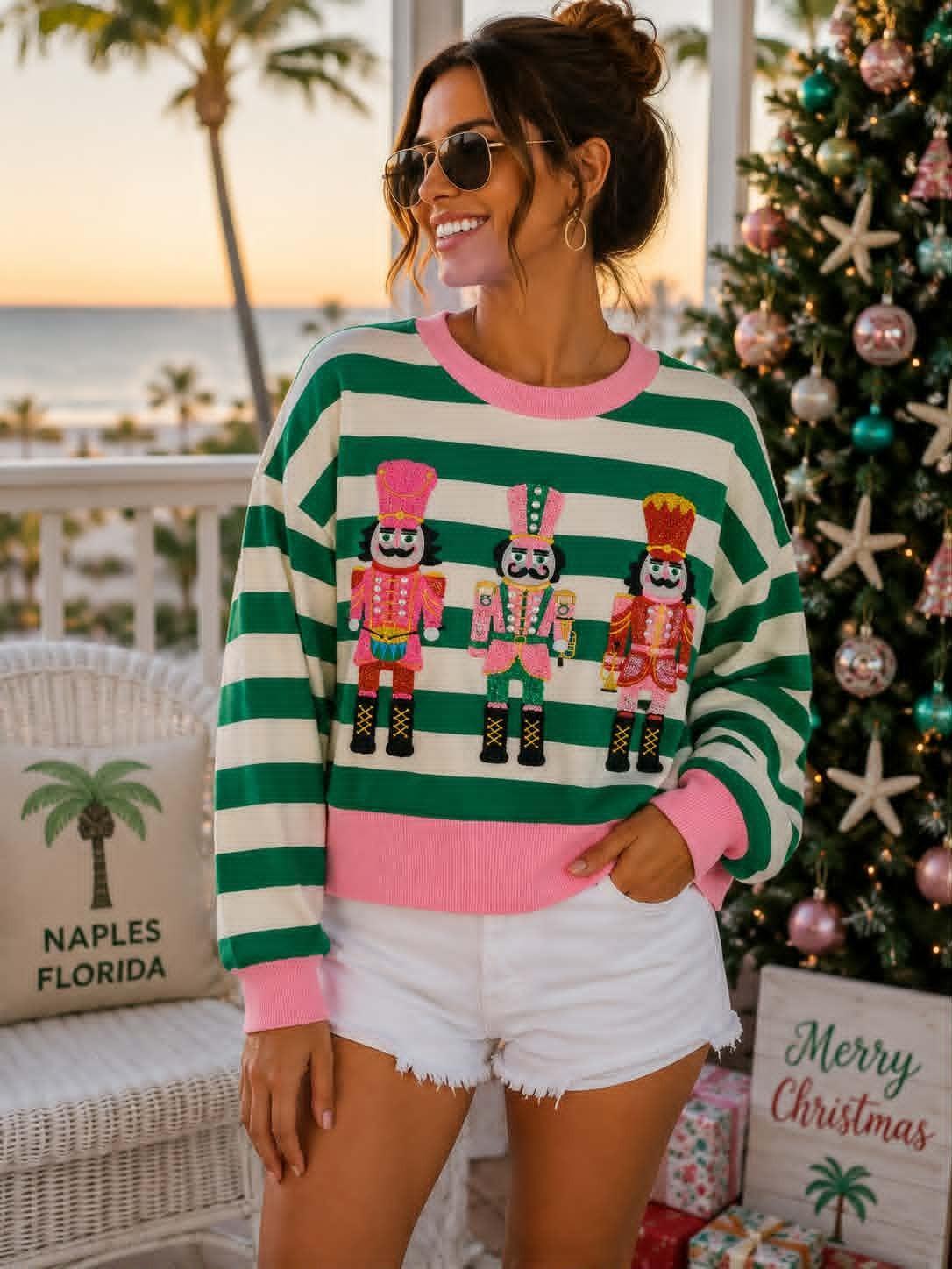 SHIRALEAH green and ivory striped knit top with pink trim and three colorful embellished nutcrackers.