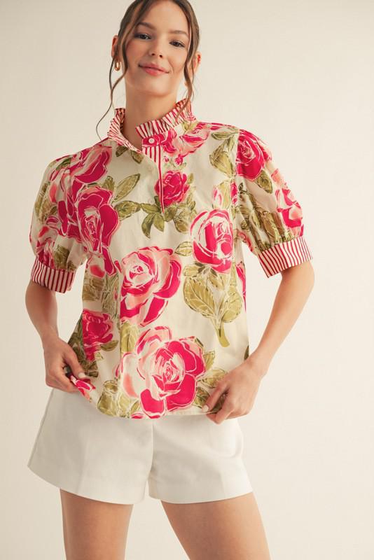 Model wearing bold rose floral blouse with striped collar and puff sleeves