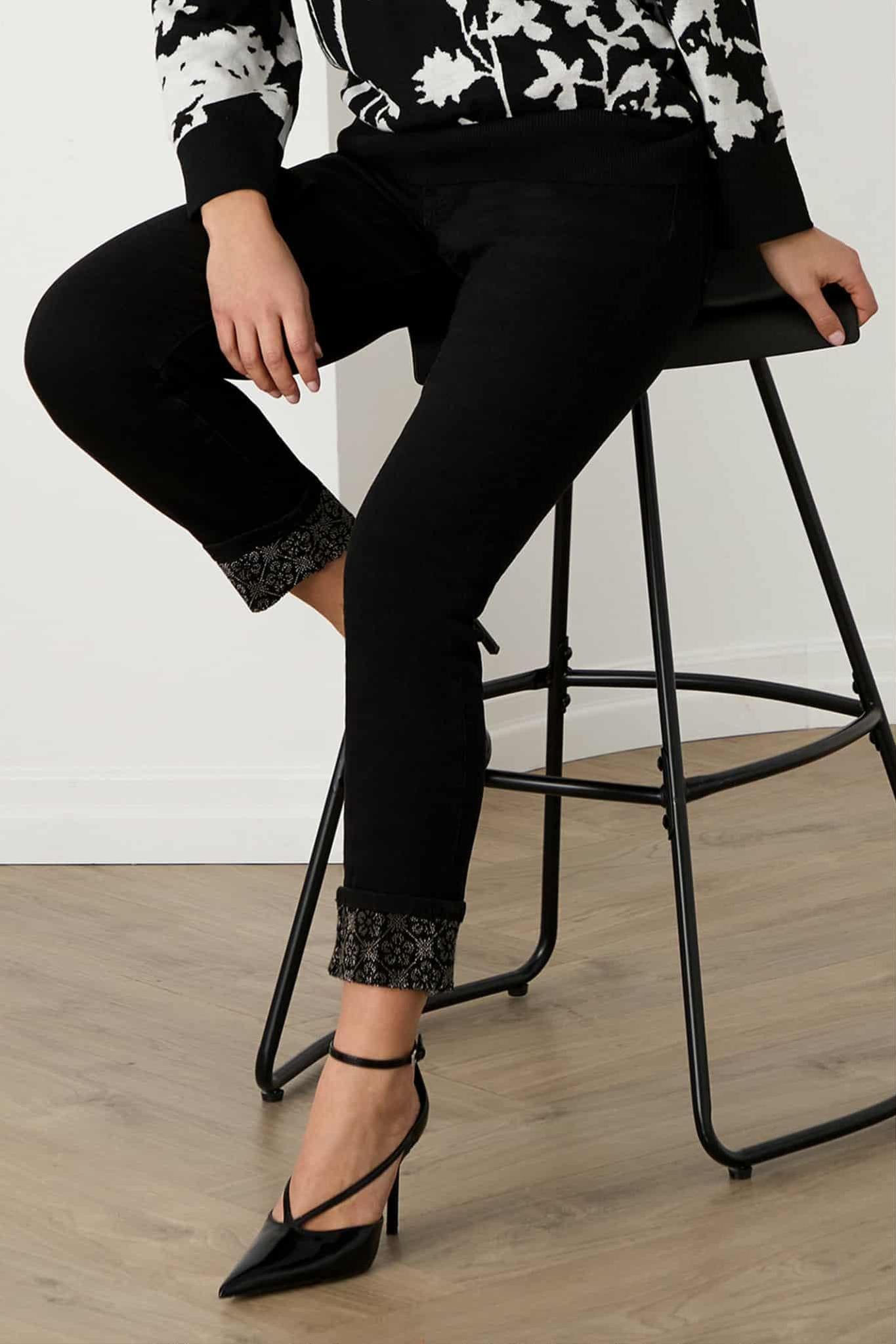 Black slim jeans with sparkling embellished ankle cuff, styled with heels