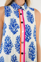 Sleeveless dress with blue coral pattern and colorful buttons, closeup