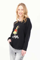 Model wearing Gabby Isabella black sweater featuring a colorful fashion-girl graphic with a yellow coat and red handbag,  WHITE BACKGROUND— Petunias of Naples