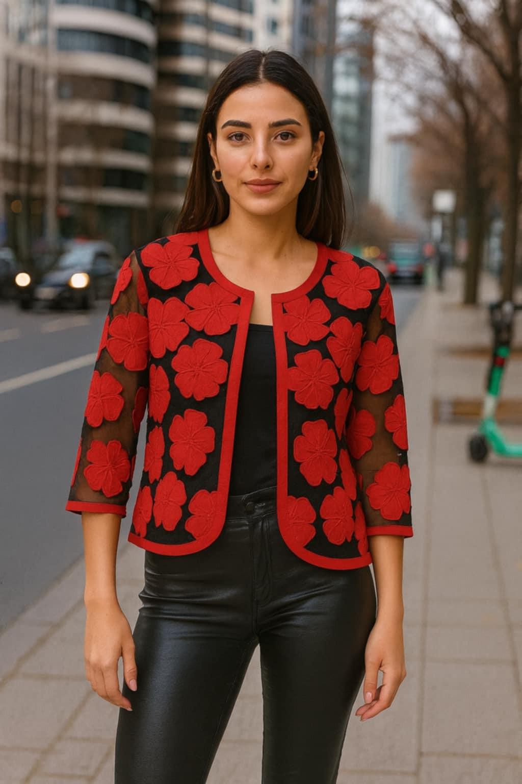 Woman wearing Parsley & Sage red floral embroidered sheer jacket over black top with leather pants