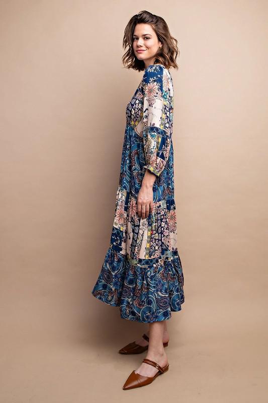 Woman wearing a long, floral-patterned dress against a beige background