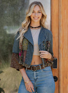 Woman wearing boho patchwork denim jacket with floral sleeves and ruffle cuffs from Petunias of Naples