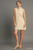 Full-length view of beige sleeveless dress with circular appliqué detailing
