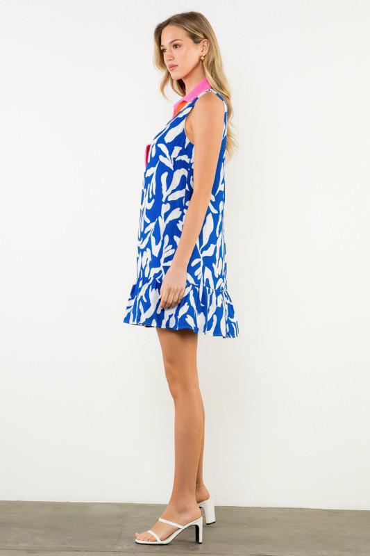 Model wearing blue and white abstract print dress styled with sandals. side view