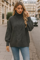 Urban chic model wearing dark gray cable-knit turtleneck sweater with balloon sleeves and jeans – cozy fall & winter fashion