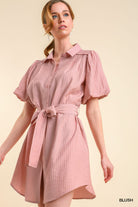 Woman wearing a pink dress with puff sleeves on a beige background