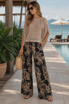 Resort style crochet knit top with relaxed fit
Neutral fringe sweater styled with wide leg pants
