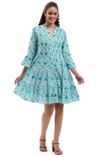 Woman wearing a blue floral dress on a white background, Parsley & Sage turquoise floral tiered cotton dress with three-quarter sleeves